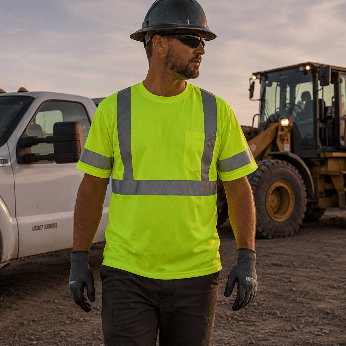 Worker wearing Class 2-style high-visibility vest near industrial equipment